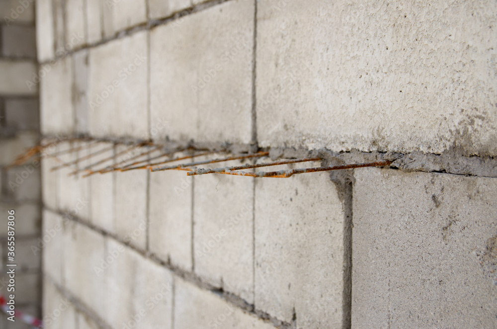 gray brick wall with iron bars reinforcement during construction gray brick wall with iron bars reinforcement during construction