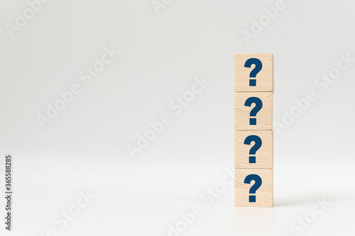 Wooden cube block shape with sign question mark symbol on white background photo