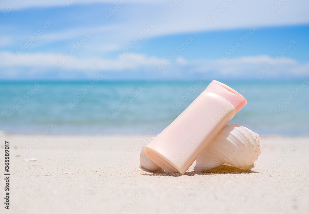 Sunsreen protection UV A,UV B. with sea shell on sand beach and blur image of sea Sunsreen protection UV A,UV B. with sea shell on sand beach and blur image of sea