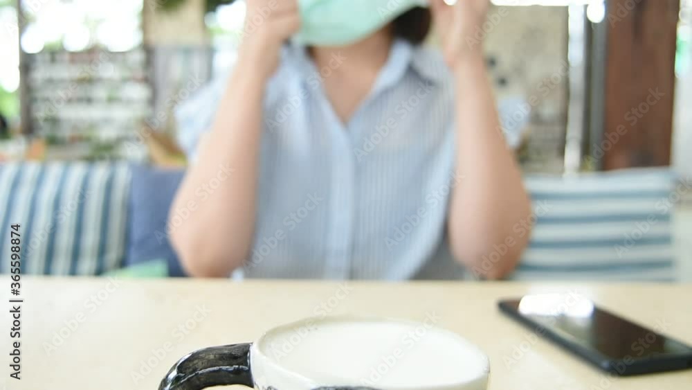 New normal relaxing woman in coffee shop on the beach with face mask and use smartphone social network. Happiness end of stage quarantine coronavirus New normal relaxing woman in coffee shop on the beach with face mask and use smartphone social network. Happiness end of stage quarantine coronavirus