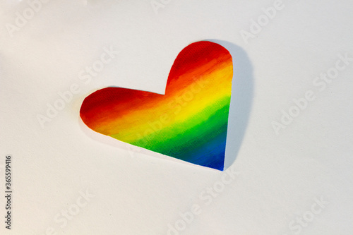 paper heart painted rainbow color by using chalk color on white background. LGBT concept