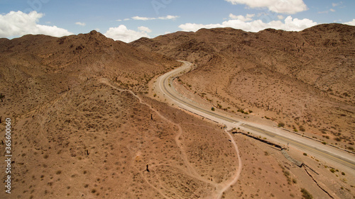 Getaway. Desert road. Aerial view of the asphalt highway across the arid desert and mountains. 