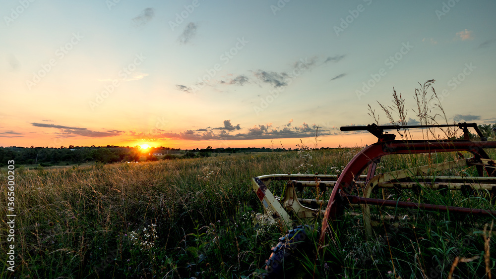 Fototapeta premium hay rake next to a prairie field