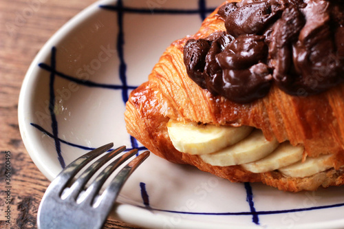 close-up croissant sandwich with banana and chocolate cream
