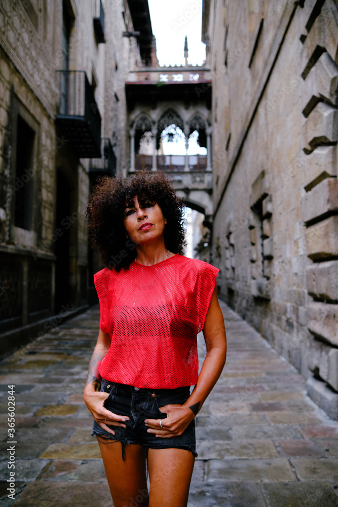 mature woman in front of Pont del Bisbe in Gothic Quarter, Barcelona