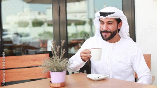 Arab man in kandora drinking coffee