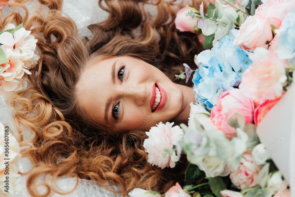Beautiful girl with beautiful makeup on her face and hairstyle with a large luxurious bouquet of flowers, advertising for cosmetologists and florists with decorators Beautiful girl with beautiful makeup on her face and hairstyle with a large luxurious bouquet of flowers, advertising for cosmetologists and florists with decorators
