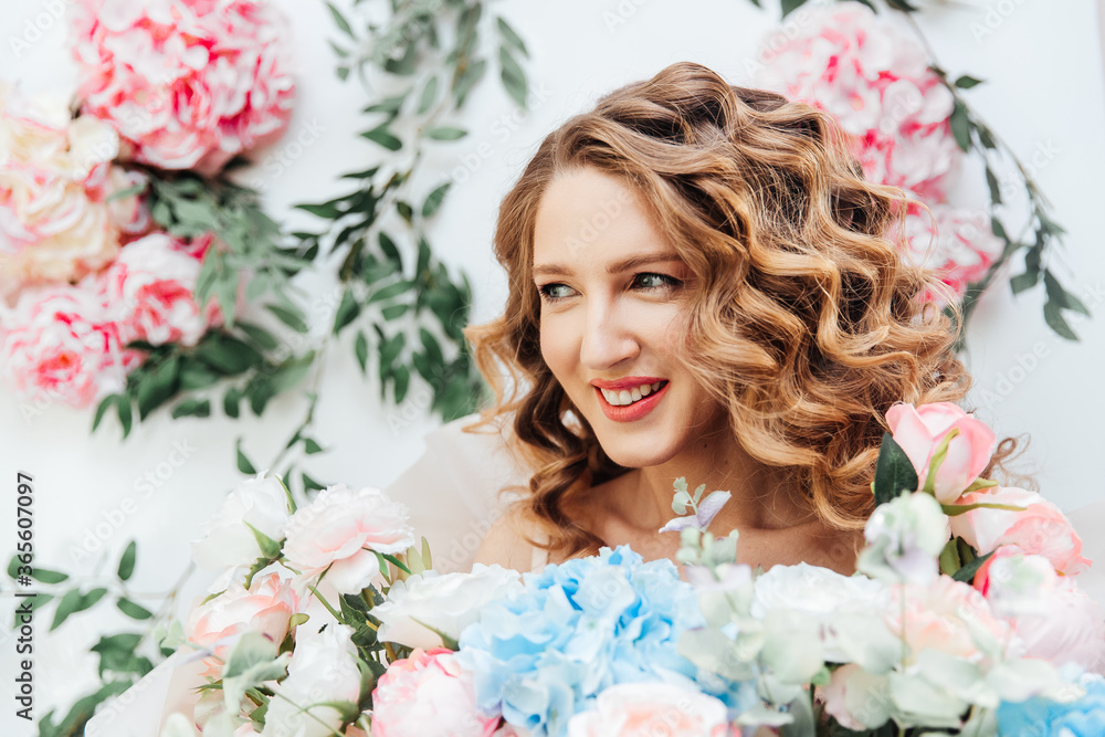 Beautiful girl with beautiful makeup on her face and hairstyle with a large luxurious bouquet of flowers, advertising for cosmetologists and florists with decorators Beautiful girl with beautiful makeup on her face and hairstyle with a large luxurious bouquet of flowers, advertising for cosmetologists and florists with decorators
