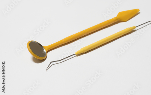 Yellow color dentist tools on white background.