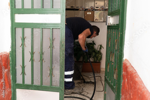 Obraz na płótnie Worker cleans the drains hatch and removes dirt and debris from the sewer. Plumber cleans the sewer w salonie