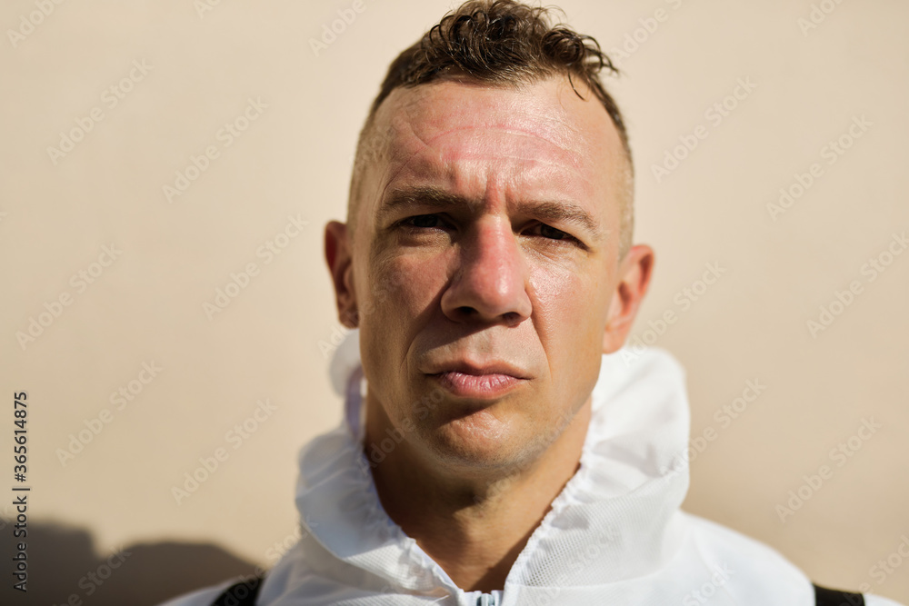 Fatigued sanitation worker after finishing a disinfection of contaminated areas. Fatigued sanitation worker after finishing a disinfection of contaminated areas.