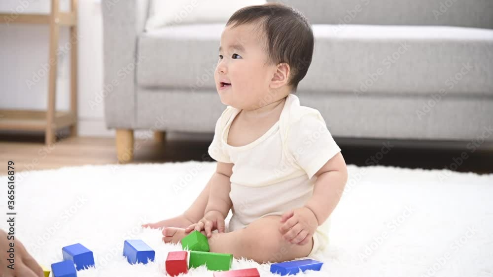 積木を倒して遊ぶ赤ちゃん