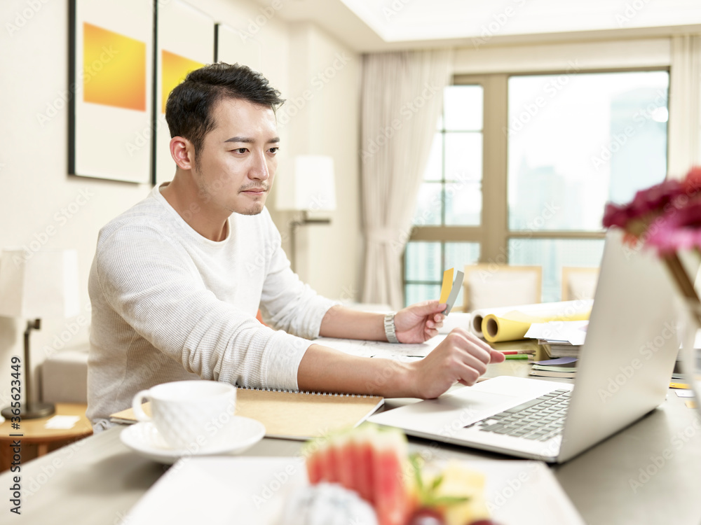 young asian man designer working from home using laptop computer contacting client young asian man designer working from home using laptop computer contacting client
