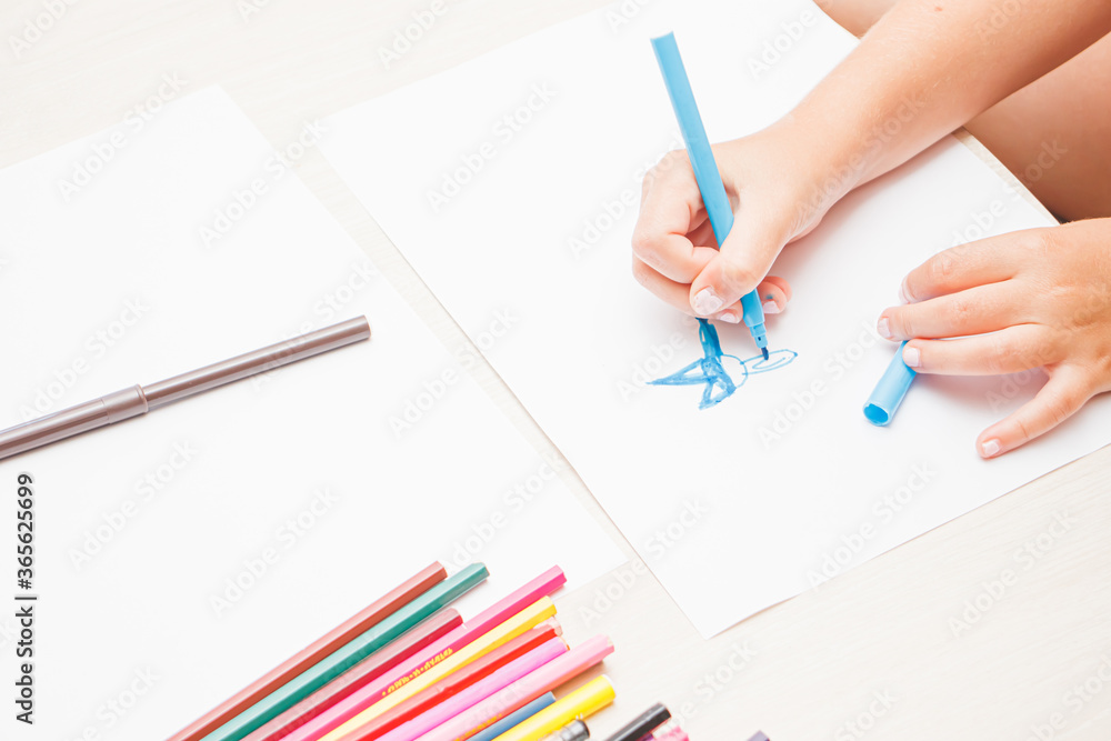 Favorite activity of the child. A happy family. The girl draws with colored markers. Girl's hands. Favorite activity of the child. A happy family. The girl draws with colored markers. Girl's hands.
