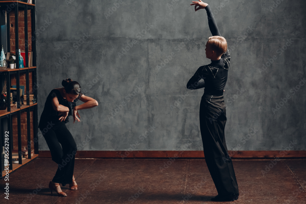 Young professional sport dancers dancing in ballroom Paso doble