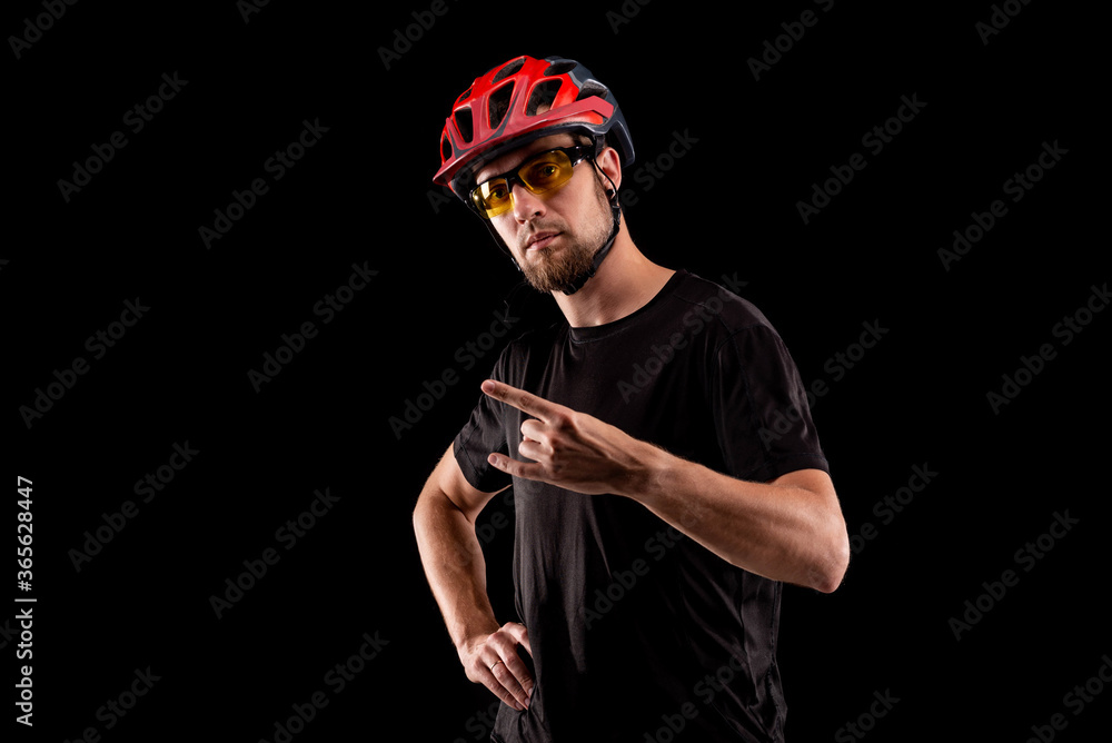 Portrait of a cyclist in a bright helmet and glasses isolated on a black background. Portrait of a cyclist in a bright helmet and glasses isolated on a black background.