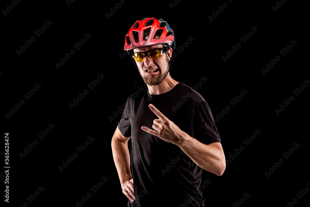Portrait of a cyclist in a bright helmet and glasses isolated on a black background. Portrait of a cyclist in a bright helmet and glasses isolated on a black background.