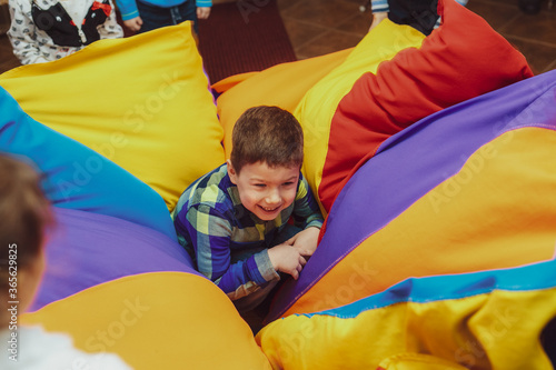 child plays in a colorful blanket