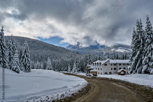 Winter landscape from the mountain with fir forest, snow and blue sky with clouds