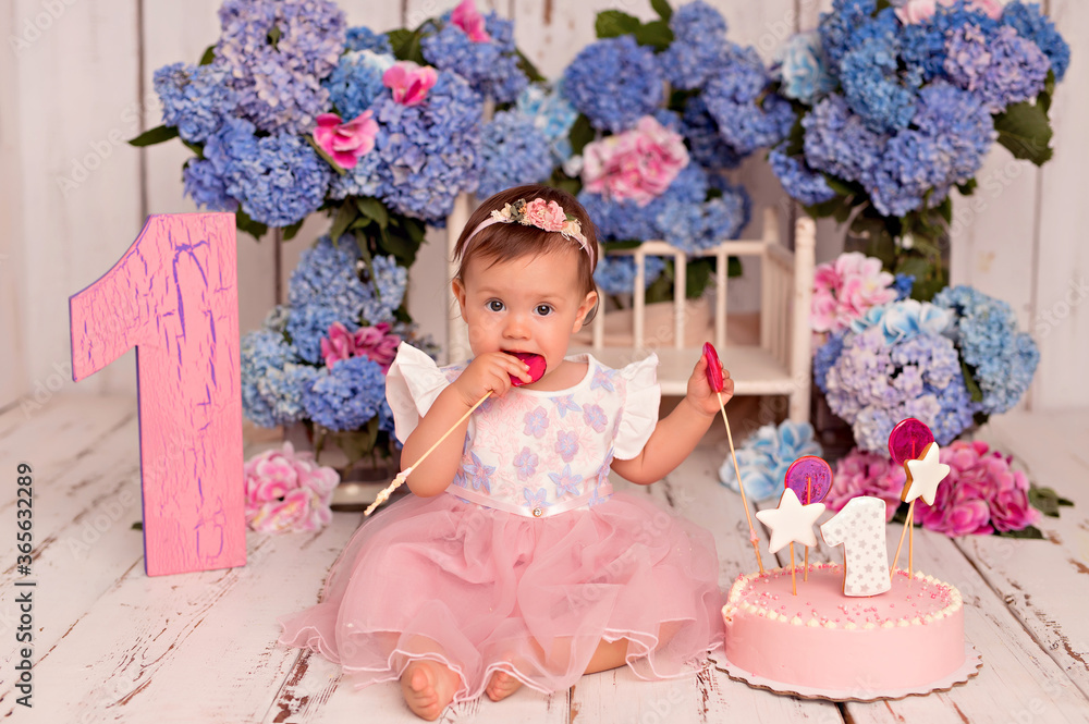 Happy girl child in dress eating birthday cake. Bouquets with blue and pink hydrangea flowers Happy girl child in dress eating birthday cake. Bouquets with blue and pink hydrangea flowers