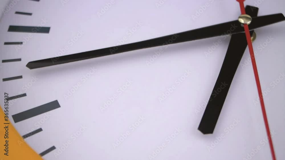 Round clock with black and red pointers close up Round clock with black and red pointers close up