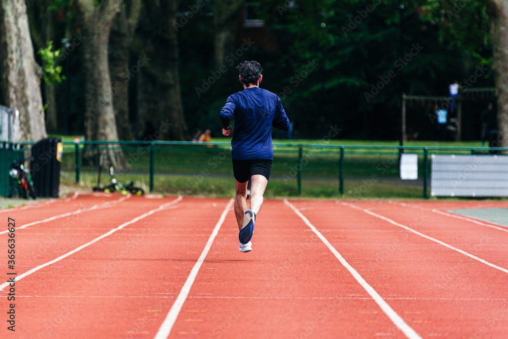 Man practicing running in the running tracks.