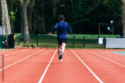 Man practicing running in the running tracks. © Angel Santana