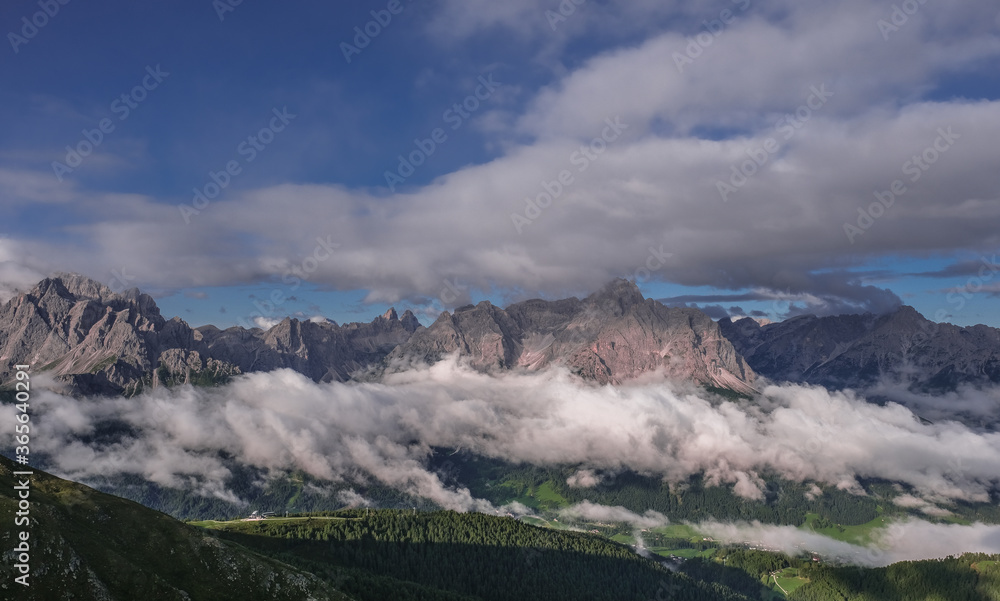 Unusual view of the Sesto Dolomites in Italy wrapped in clouds from top to bottom as seen from Carnic Peace Trail from Sillianer refuge to Obstansersee refuge on top of the Carnic Alps ridge, Austria. Unusual view of the Sesto Dolomites in Italy wrapped in clouds from top to bottom as seen from Carnic Peace Trail from Sillianer refuge to Obstansersee refuge on top of the Carnic Alps ridge, Austria.