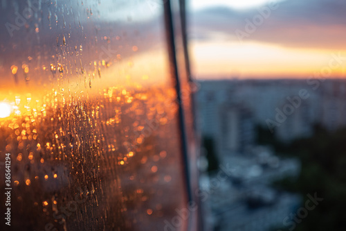 wet the window glass and the reflection of the sunset, the texture of the glass with rain drops.