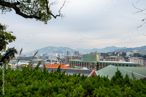 NAGASAKI, Japan. Nagasaki landscape view with autumn trees and overcast sky seen from Glover Garden on the hill overlooking the city. 
