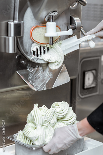 Pile of ready-made ice cream falling out of the freezer at the manufacturing, close-up