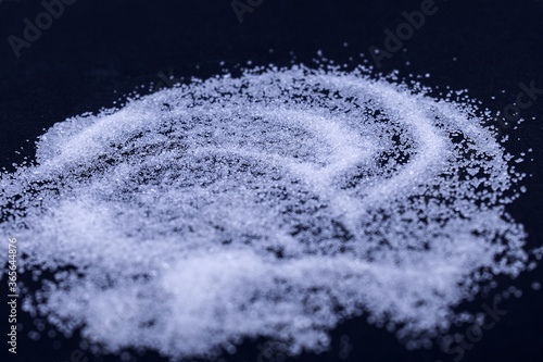 scattered white sugar on a dark background
