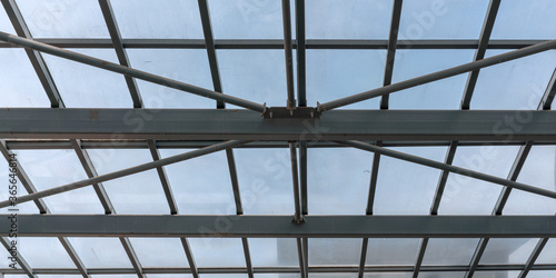Architectural detail of transparent metal roof of railway station blue sky background
