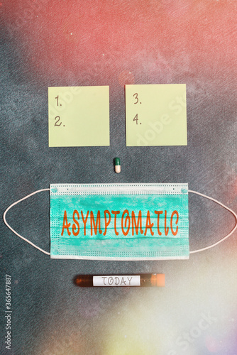 Conceptual hand writing showing Asymptomatic. Concept meaning a condition or an individual producing or showing no symptoms Set of medical equipment for health condition assessment photo