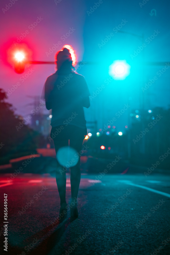 Beautiful women's back under traffic lights on the road