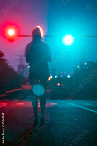 Beautiful women's back under traffic lights on the road
