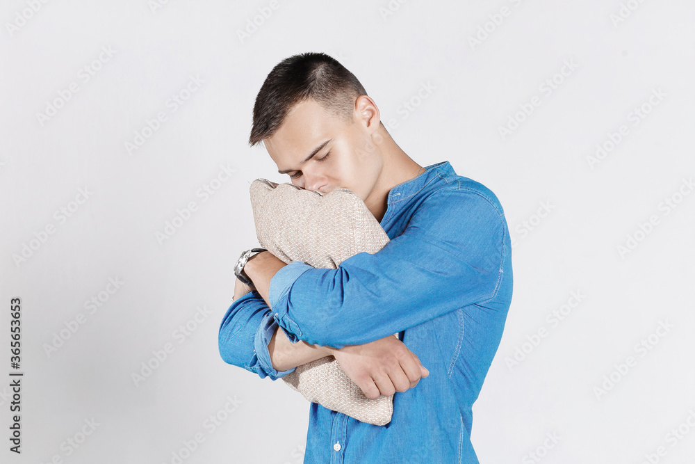 Tired man want to sleep huging a big pillow. INSOMNIA CONCEPT. Happy to sleep. Man suffering grom insomnia. Tired man want to sleep huging a big pillow. INSOMNIA CONCEPT. Happy to sleep. Man suffering grom insomnia.