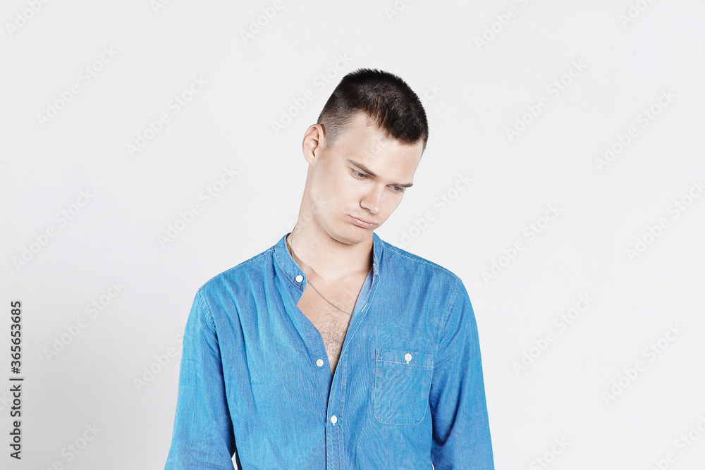Studio shot of young man looking at the camera. Isolated on white background. Horizontal format, he has a serious face, he is wearing a blue T-shirt. Studio shot of young man looking at the camera. Isolated on white background. Horizontal format, he has a serious face, he is wearing a blue T-shirt.