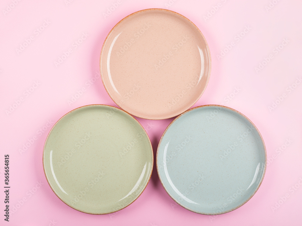 Three pastel color ceramic dishes on pink background. Home dinnerware concept Three pastel color ceramic dishes on pink background. Home dinnerware concept