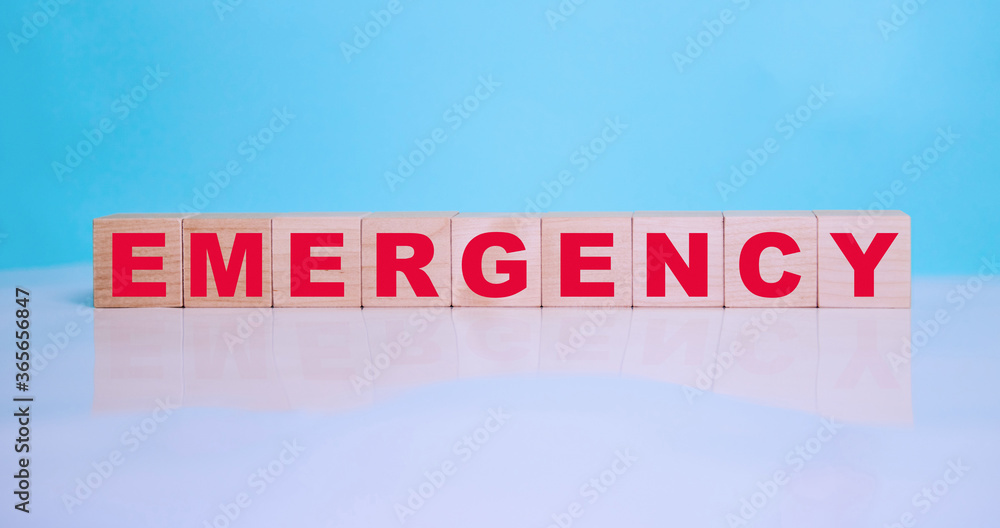 Emergency the inscription in red on wooden cubes on a blue background. Medical concept.