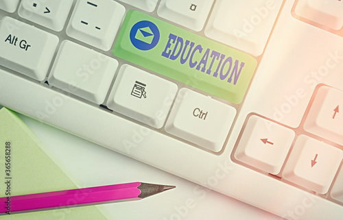 Text sign showing Education. Business photo showcasing the process of obtaining or giving systematic training at school Different colored keyboard key with accessories arranged on empty copy space photo