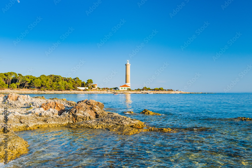 Obraz premium Lighthouse of Veli Rat on the island of Dugi Otok, Croatia, beautiful seascape and rocks in foreground