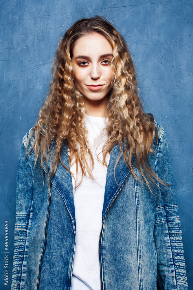 young pretty blond curly girl posing happy smiling on blue background, lifestyle people concept young pretty blond curly girl posing happy smiling on blue background, lifestyle people concept