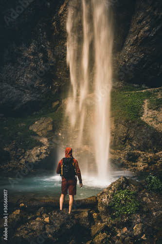 Fototapeta Naklejka Na Ścianę i Meble -  Man standing near big Waterfall in Austria in Summer