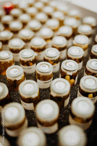 pharmaceuticals in numbered glasses, ampoules with numbers on it filled with pills, capsules, numbers in close up, symbol of pharmacy and healthcare