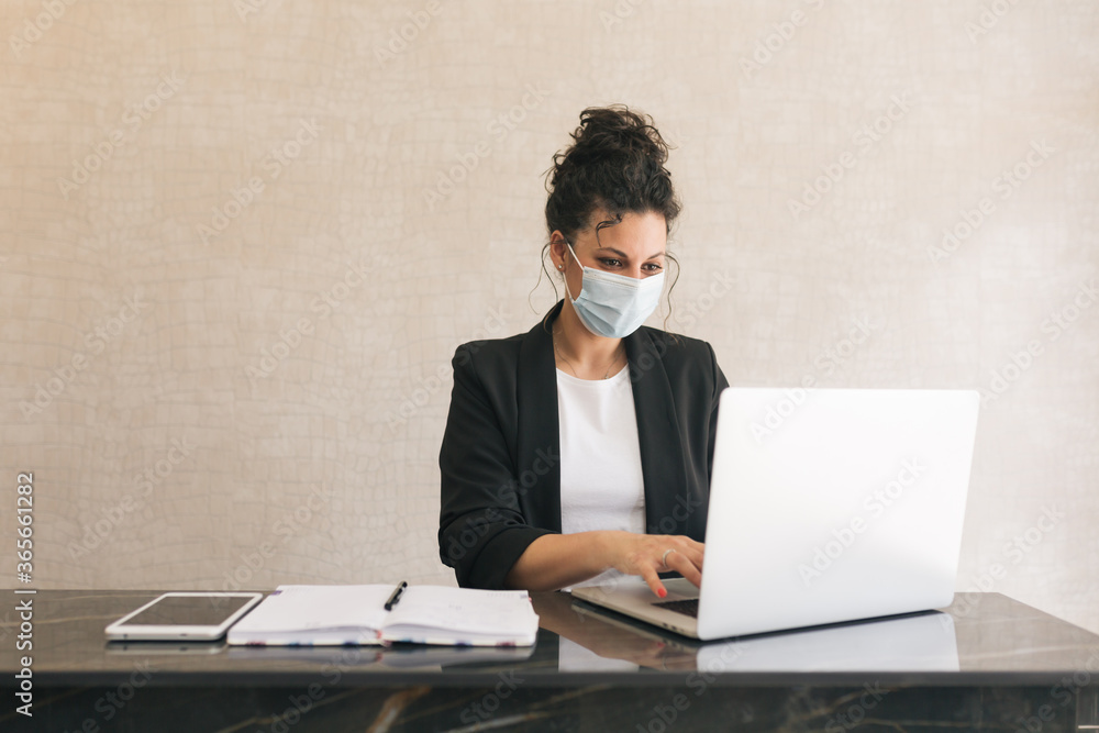 brown-haired, uptight receptionist with a white T-shirt and black jacket with round glasses and virus mask, working with a laptop brown-haired, uptight receptionist with a white T-shirt and black jacket with round glasses and virus mask, working with a laptop