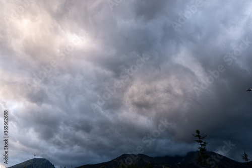 storm clouds over the mountains and small birds in a dark sky, slovakia tatras