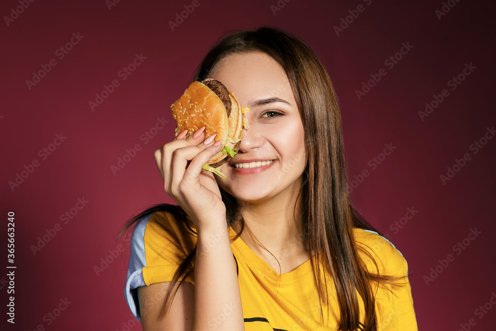 Woman eat burger sandwich with hungry mouth on pink background. Closeup composition of Fast food concept. Woman eat burger sandwich with hungry mouth on pink background. Closeup composition of Fast food concept.