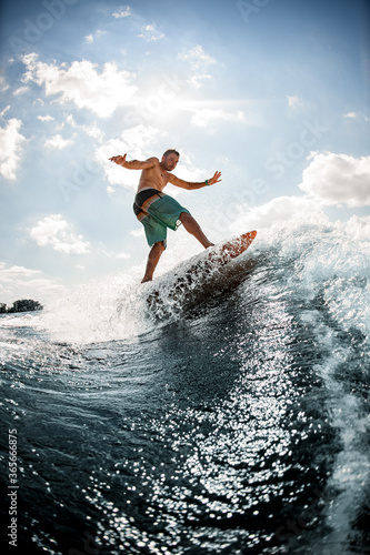 beautiful view of man on surfboard who is riding up the wave