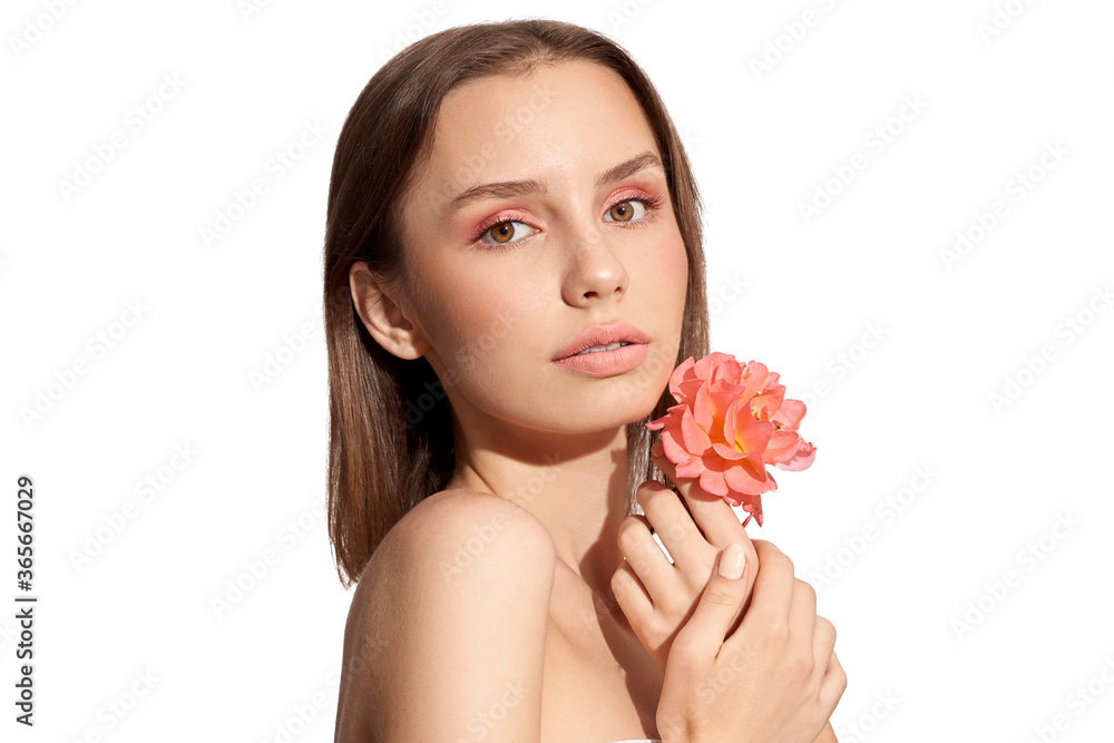 Young beautiful woman with pink flower on white isolated background. Woman with natural make up.